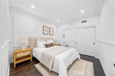 bedroom with dark wood-type flooring and a closet