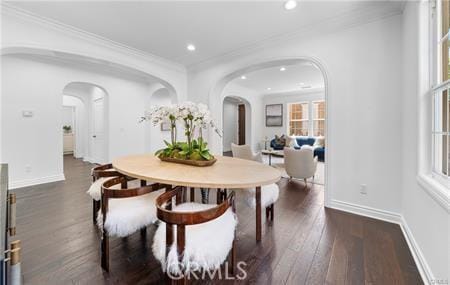 dining space with dark hardwood / wood-style flooring and crown molding