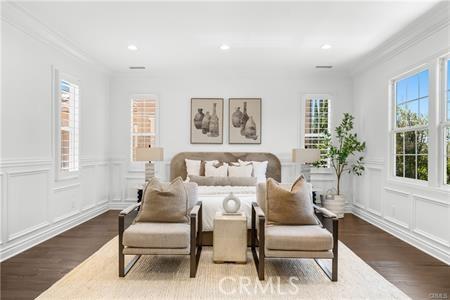 sitting room with dark wood-type flooring and ornamental molding