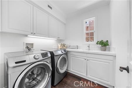 laundry area with cabinets, independent washer and dryer, and sink