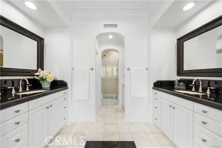 bathroom featuring tile patterned floors, walk in shower, and vanity