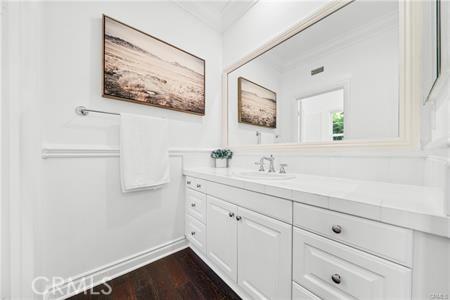 bathroom featuring vanity, crown molding, and hardwood / wood-style floors