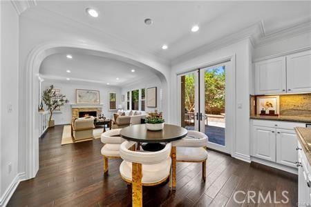 dining area featuring french doors, dark wood-type flooring, and ornamental molding