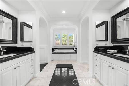 bathroom with tiled bath, tile patterned flooring, ornamental molding, and vanity