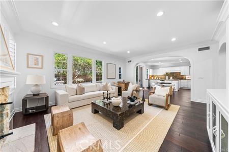 living room featuring dark wood-type flooring and ornamental molding