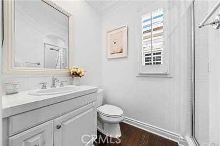 bathroom with a shower with door, hardwood / wood-style floors, toilet, and vanity