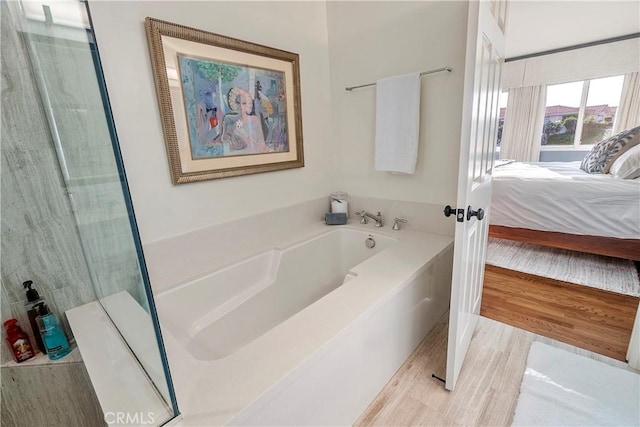 bathroom with hardwood / wood-style flooring and separate shower and tub