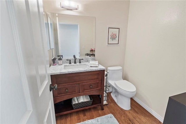 bathroom featuring hardwood / wood-style flooring, vanity, and toilet