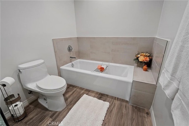 bathroom with hardwood / wood-style flooring, a bathing tub, and toilet