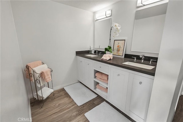 bathroom featuring vanity, wood-type flooring, and a textured ceiling