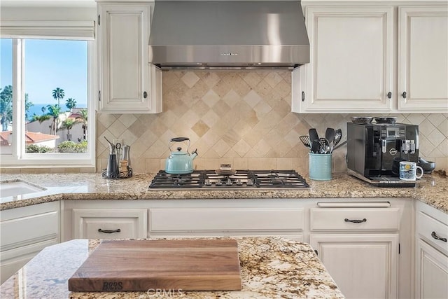 kitchen with white cabinetry and wall chimney range hood