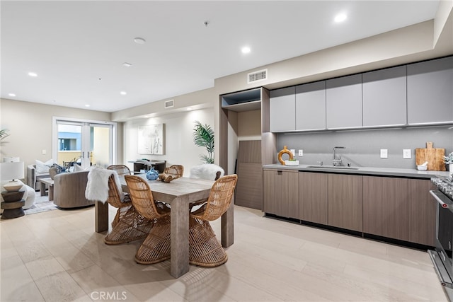 dining area with french doors, sink, and light hardwood / wood-style floors