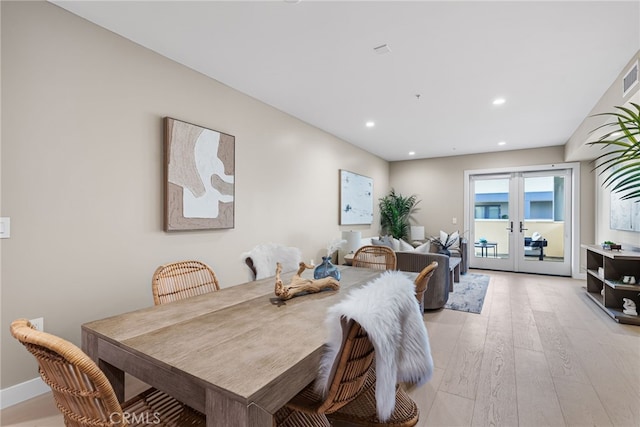 dining room with french doors and light hardwood / wood-style floors