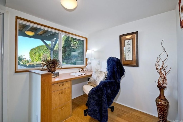 office space with light hardwood / wood-style floors and built in desk