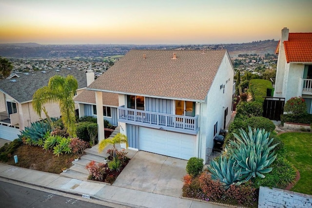 view of front of property featuring a garage and a balcony