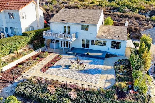 back of house with french doors, a balcony, and a patio