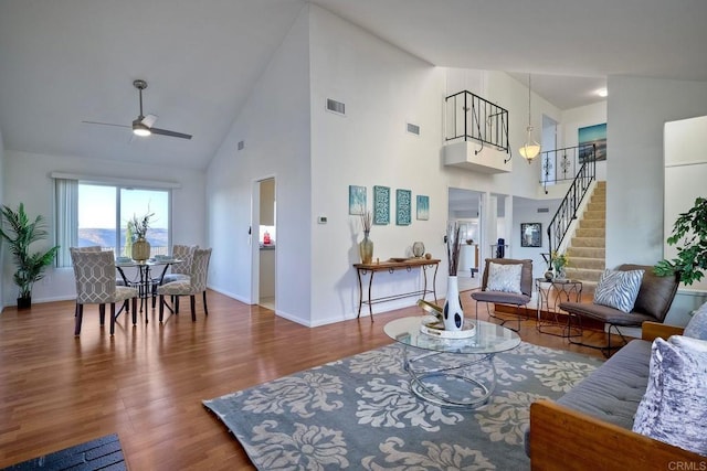 living room with high vaulted ceiling, hardwood / wood-style flooring, and ceiling fan