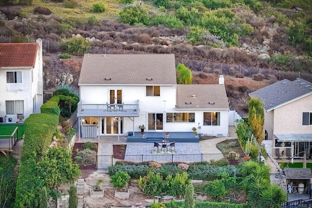 rear view of property with a balcony and a patio area