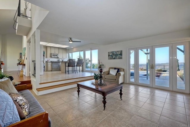 tiled living room featuring ceiling fan and french doors