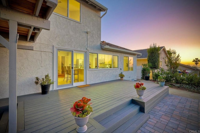 back house at dusk with a deck