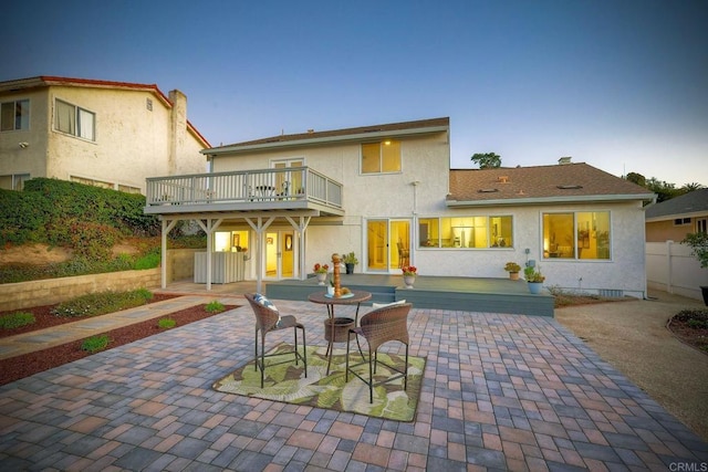 back of property featuring a balcony and a patio