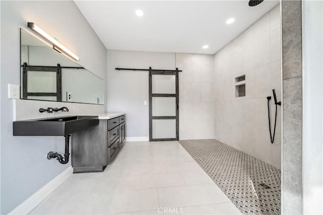 bathroom with sink, a tile shower, and tile patterned flooring