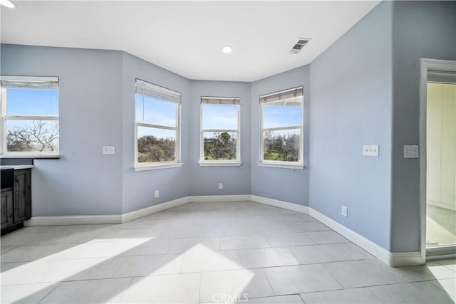 spare room featuring plenty of natural light and light tile patterned flooring