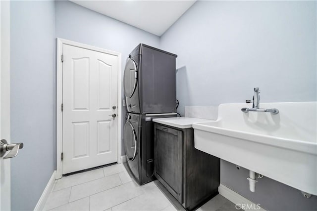 clothes washing area with stacked washer and dryer, light tile patterned flooring, and sink