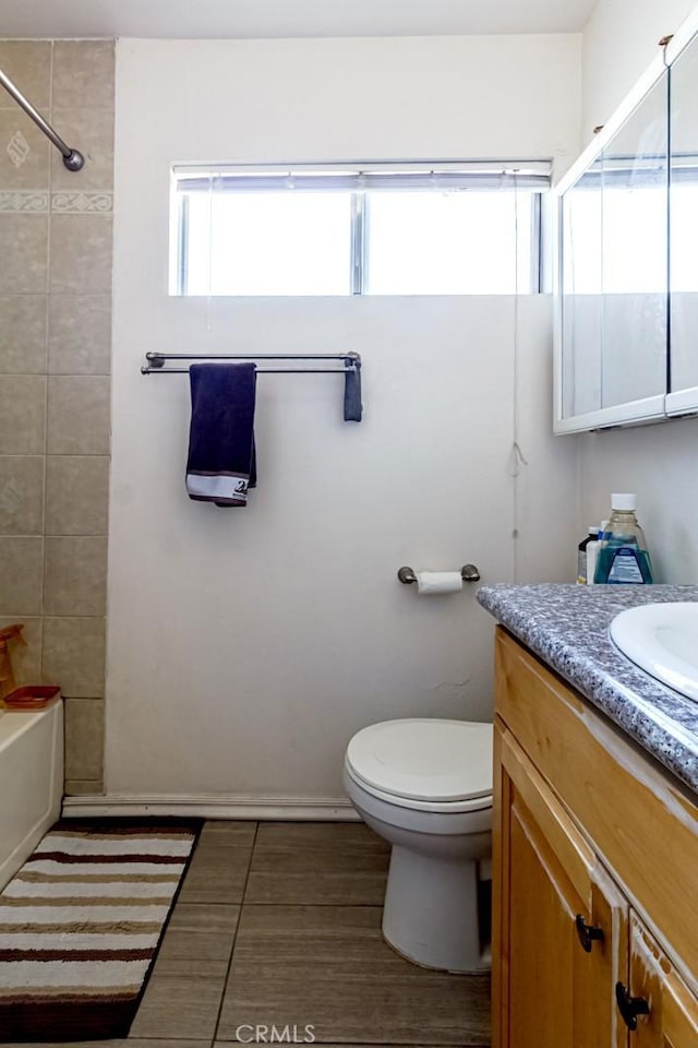 full bathroom with tiled shower / bath combo, vanity, tile patterned flooring, and toilet