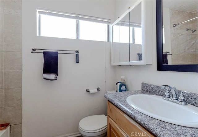 full bathroom featuring vanity, tiled shower / bath, and toilet