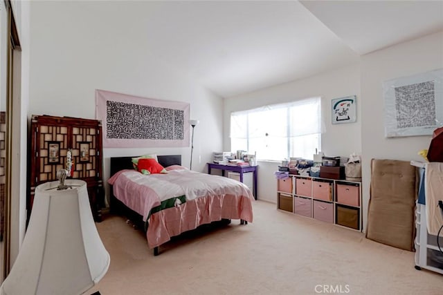 bedroom featuring light colored carpet and vaulted ceiling