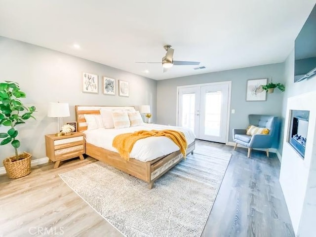 bedroom with ceiling fan, french doors, and light hardwood / wood-style flooring