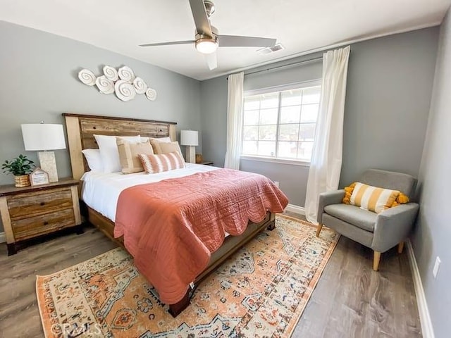 bedroom with ceiling fan and hardwood / wood-style flooring