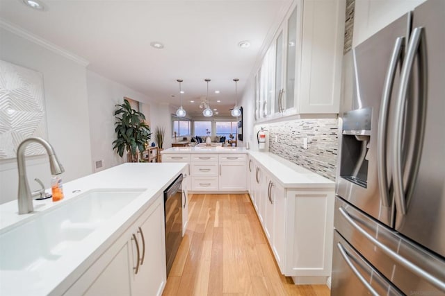 kitchen with decorative light fixtures, white cabinets, stainless steel refrigerator with ice dispenser, and sink