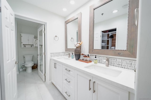 bathroom with backsplash, toilet, vanity, and tile patterned flooring