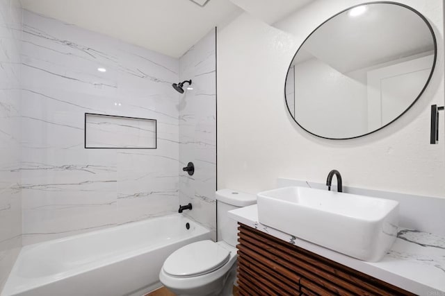 full bathroom featuring tiled shower / bath combo, vanity, and toilet