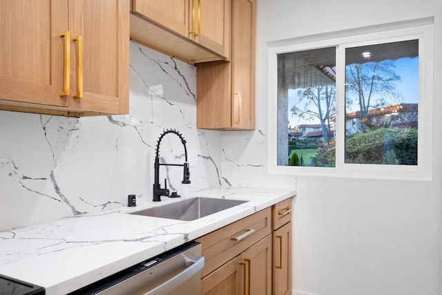 kitchen with backsplash, dishwasher, sink, light brown cabinetry, and light stone counters