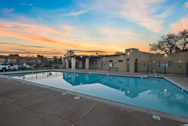 pool at dusk featuring a patio area