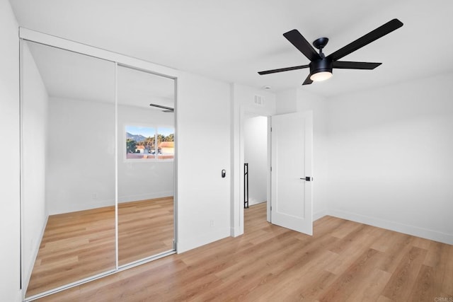 unfurnished bedroom featuring ceiling fan, a closet, and light hardwood / wood-style floors