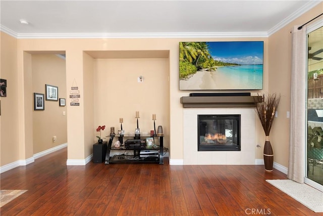 living room with dark hardwood / wood-style flooring, ornamental molding, and a fireplace