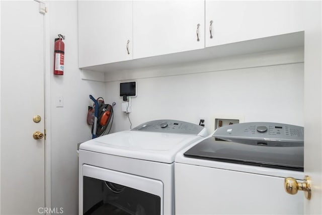 washroom with washer and clothes dryer and cabinets