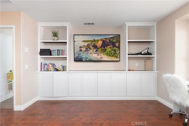 interior space featuring built in shelves and dark hardwood / wood-style flooring