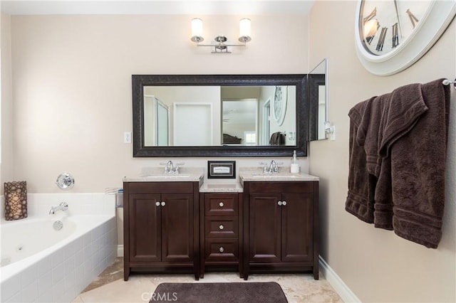 bathroom with tiled bath, tile patterned flooring, and vanity