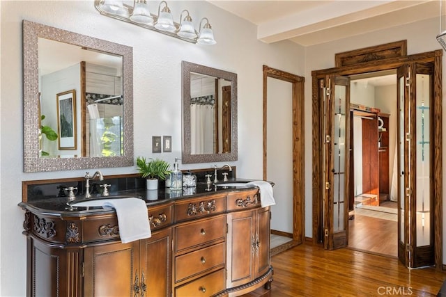 bathroom with vanity, beamed ceiling, and hardwood / wood-style flooring