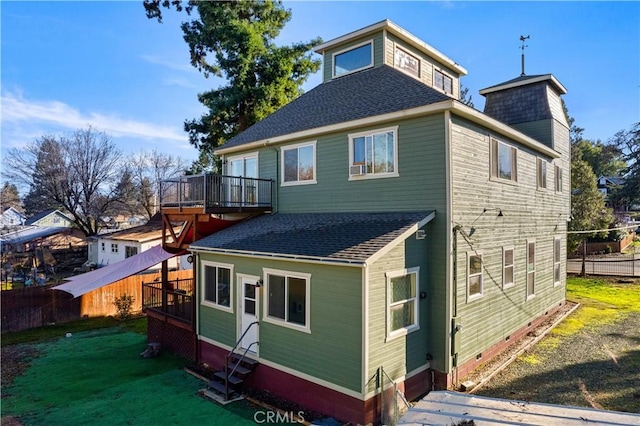 rear view of house featuring a lawn and a deck