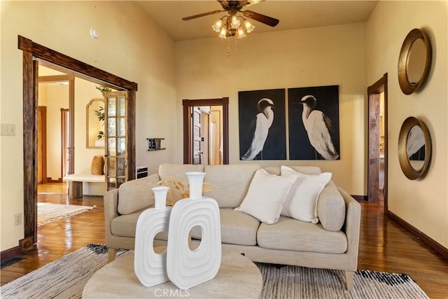 living room featuring ceiling fan and dark hardwood / wood-style floors