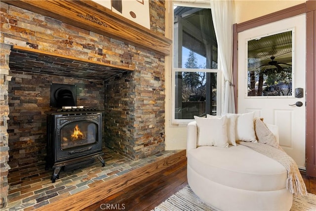 sitting room with a wood stove and hardwood / wood-style floors