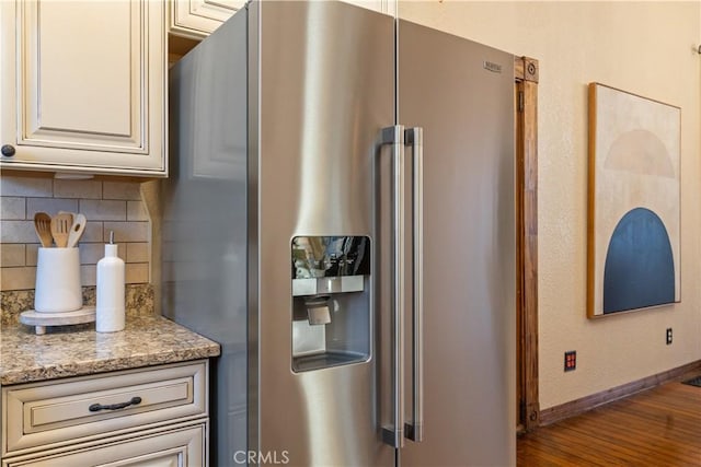 kitchen featuring decorative backsplash, light stone countertops, wood-type flooring, and high end refrigerator