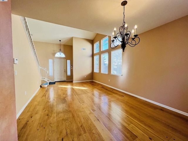 interior space with high vaulted ceiling, light hardwood / wood-style flooring, and a notable chandelier