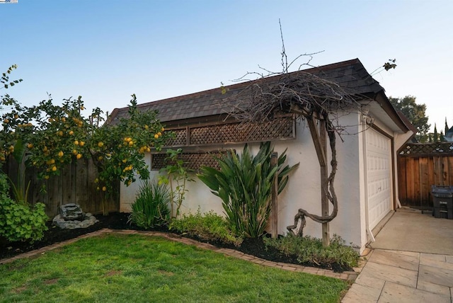 view of side of property featuring a garage and a lawn